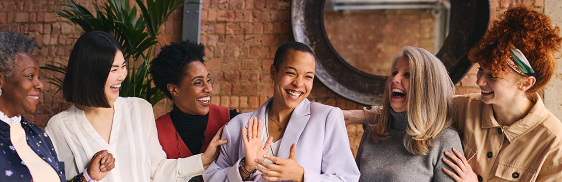 International Women's Day portrait of cheerful multi ethnic mixed age range businesswomen celebrating